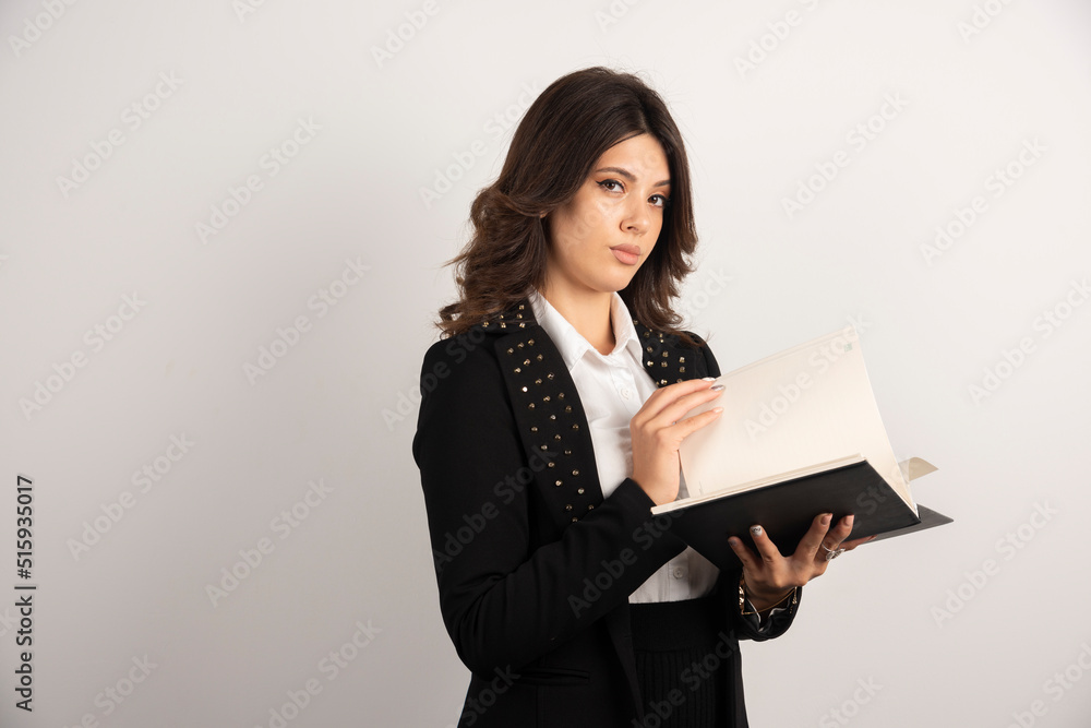 Serious teacher looking through the notebook Serious teacher looking through the notebook