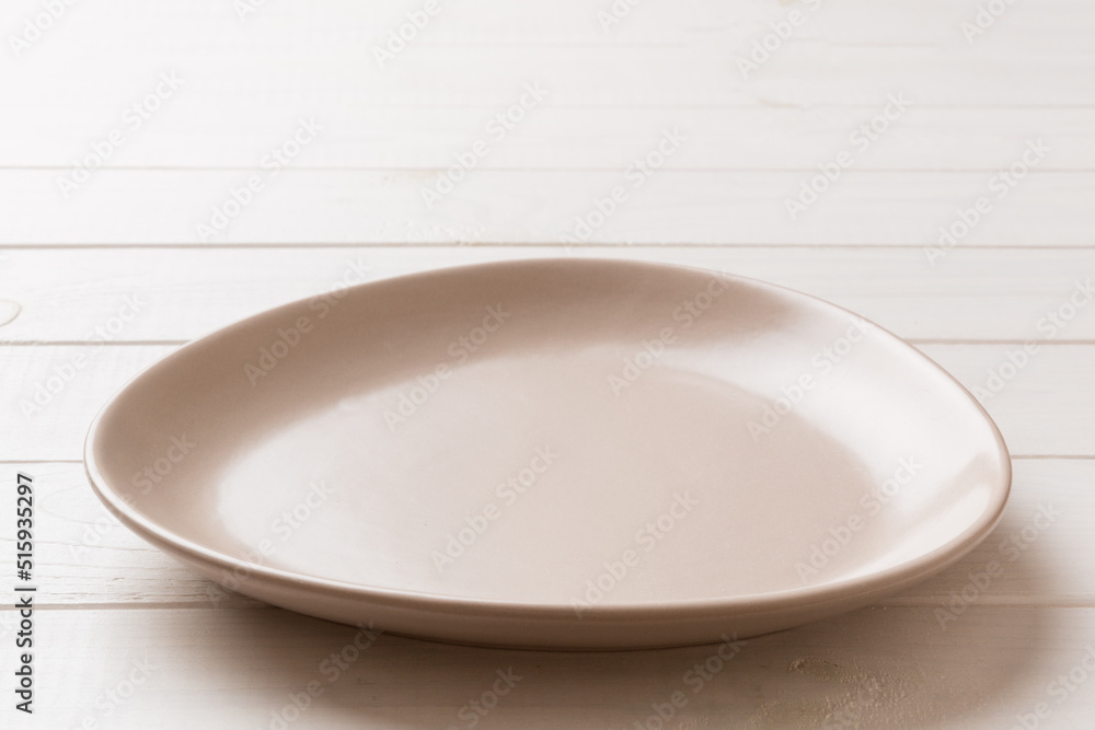 Perspective view of empty pink plate on wooden background. Empty space for your design Perspective view of empty pink plate on wooden background. Empty space for your design