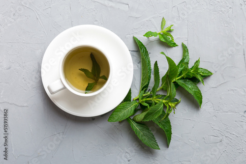 Cup of mint tea on table background. Green tea with fresh mint top view with copy space © sosiukin