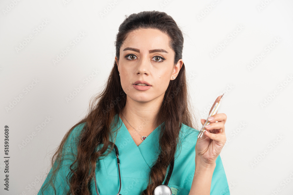 Female nurse with stethoscope holding thermometer Female nurse with stethoscope holding thermometer