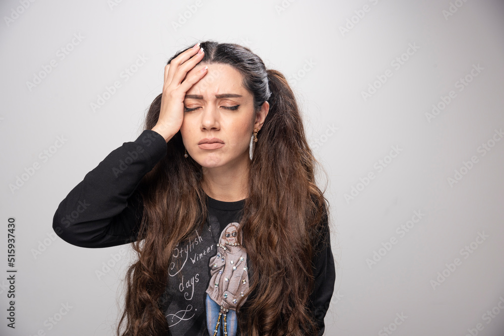 Obraz premium Young girl in printed sweatshirt having headache