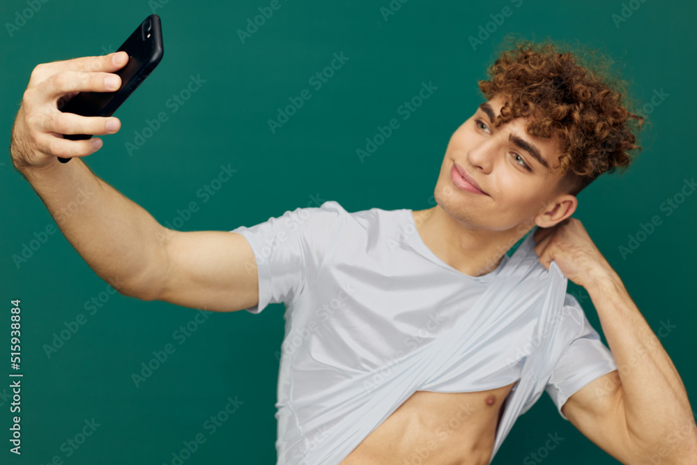 a handsome, sexy man takes pictures of his perfect abs on his phone