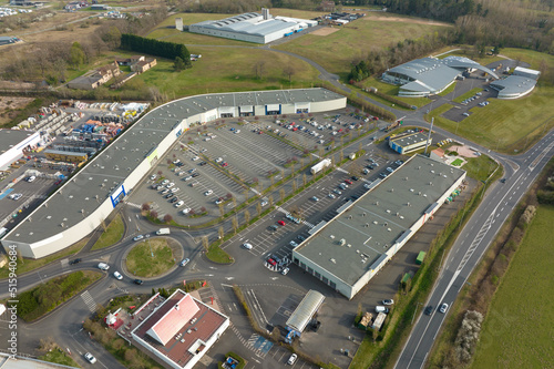 Aerial view of many colorful cars parked on parking lot with lines and markings for parking places and directions