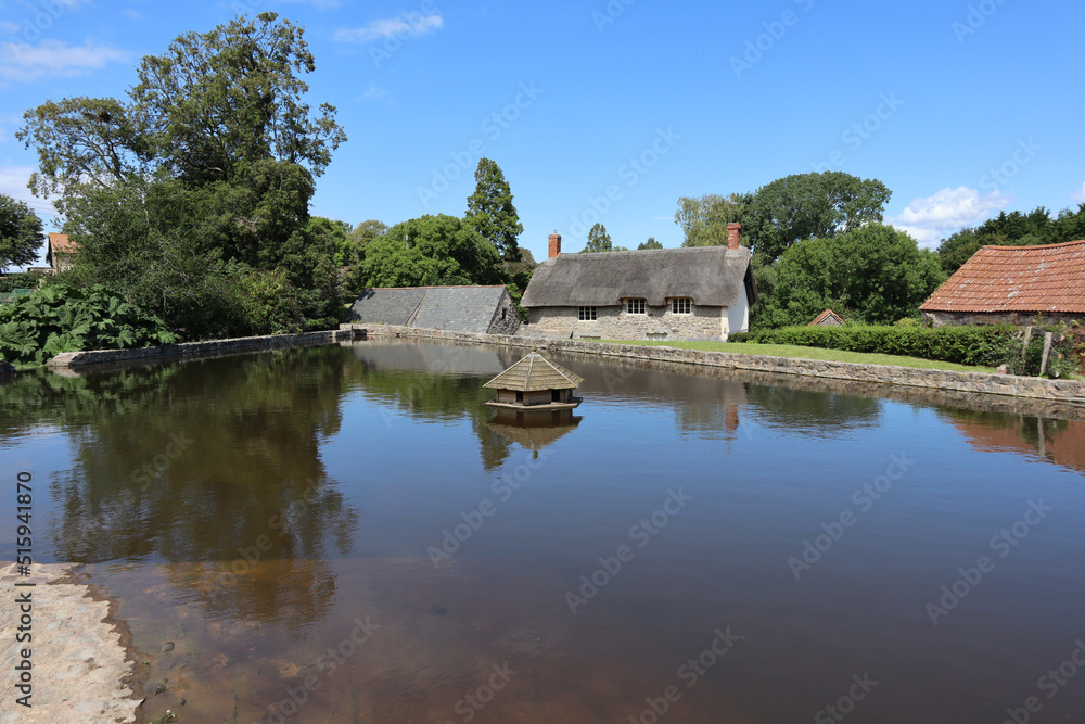 The hexagonal duck house on the village pond at East Quantoxhead in Somerset, England. Thatched cottages can be seen in the background The hexagonal duck house on the village pond at East Quantoxhead in Somerset, England. Thatched cottages can be seen in the background