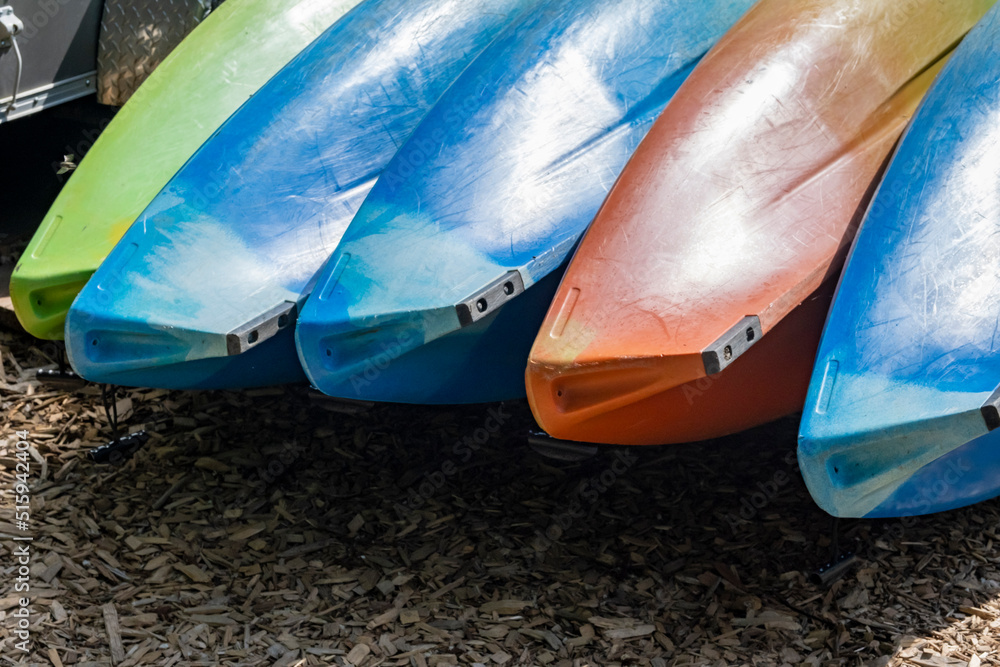 Kayaks in sun on shore awaiting rental Kayaks in sun on shore awaiting rental
