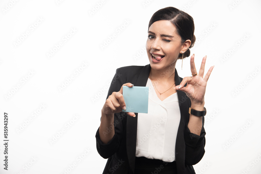 Female employee with memo pad making faces on white background Female employee with memo pad making faces on white background