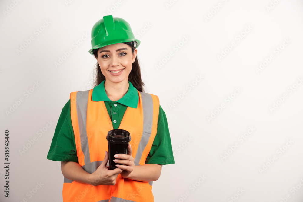 Smiling female constructor with black cup Smiling female constructor with black cup