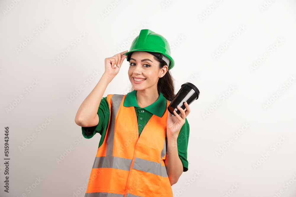 Smiling female constructor with black cup