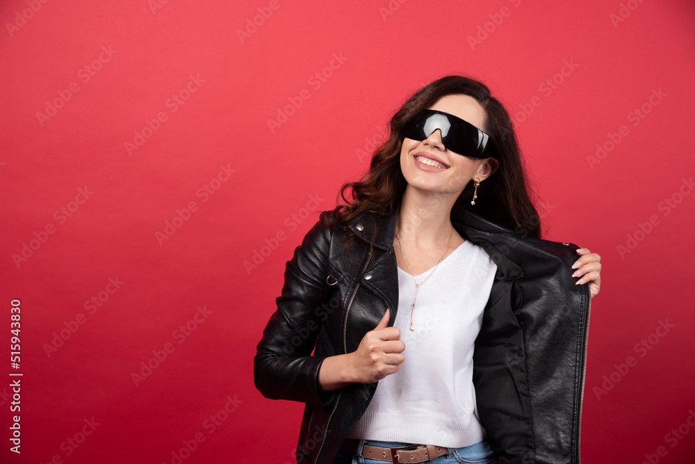 Young woman wearing black glasses on a red background Young woman wearing black glasses on a red background