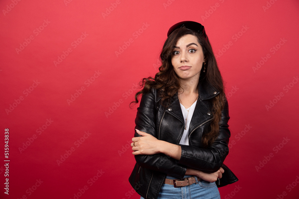 Young woman posing with crossed arms on a red background Young woman posing with crossed arms on a red background