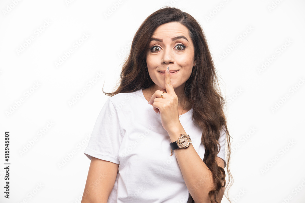 Young pretty woman in white shirt making silence sign Young pretty woman in white shirt making silence sign