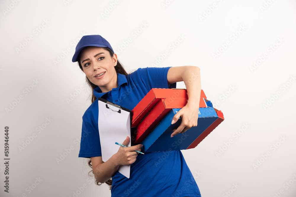 Young female courier with cardboard of pizza and clipboard Young female courier with cardboard of pizza and clipboard