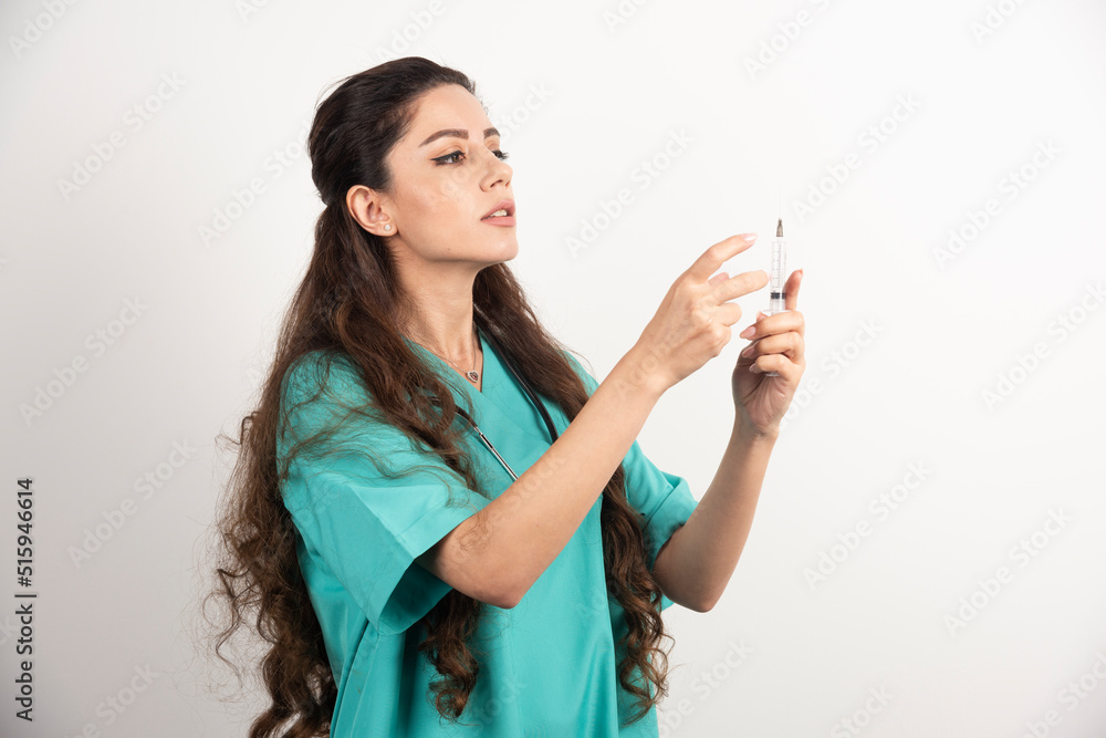 Female nurse with stethoscope holding a syringe in her hands Female nurse with stethoscope holding a syringe in her hands