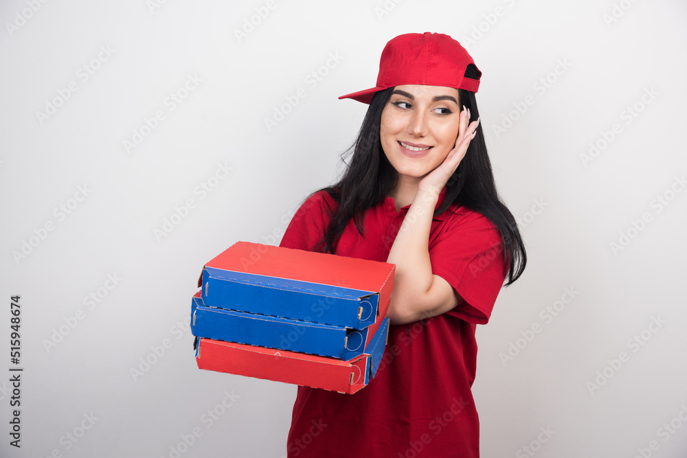 Young delivery woman holding a three boxes of pizza on white background Young delivery woman holding a three boxes of pizza on white background