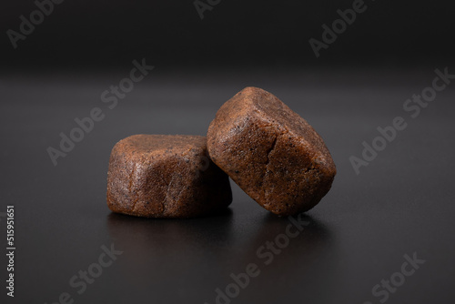 dark lumps of cannabis Moroccan hashish with high thc on a black background.