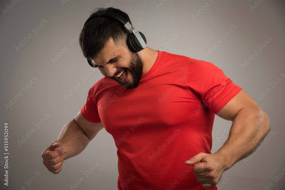 Male dj in red shirt wearing headphones and dancing Male dj in red shirt wearing headphones and dancing