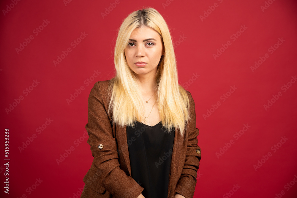 Businesswoman in casual outfit standing on red background Businesswoman in casual outfit standing on red background