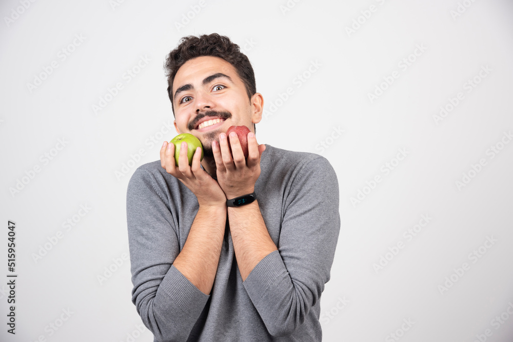 Happy man smiling with apples on gray background Happy man smiling with apples on gray background