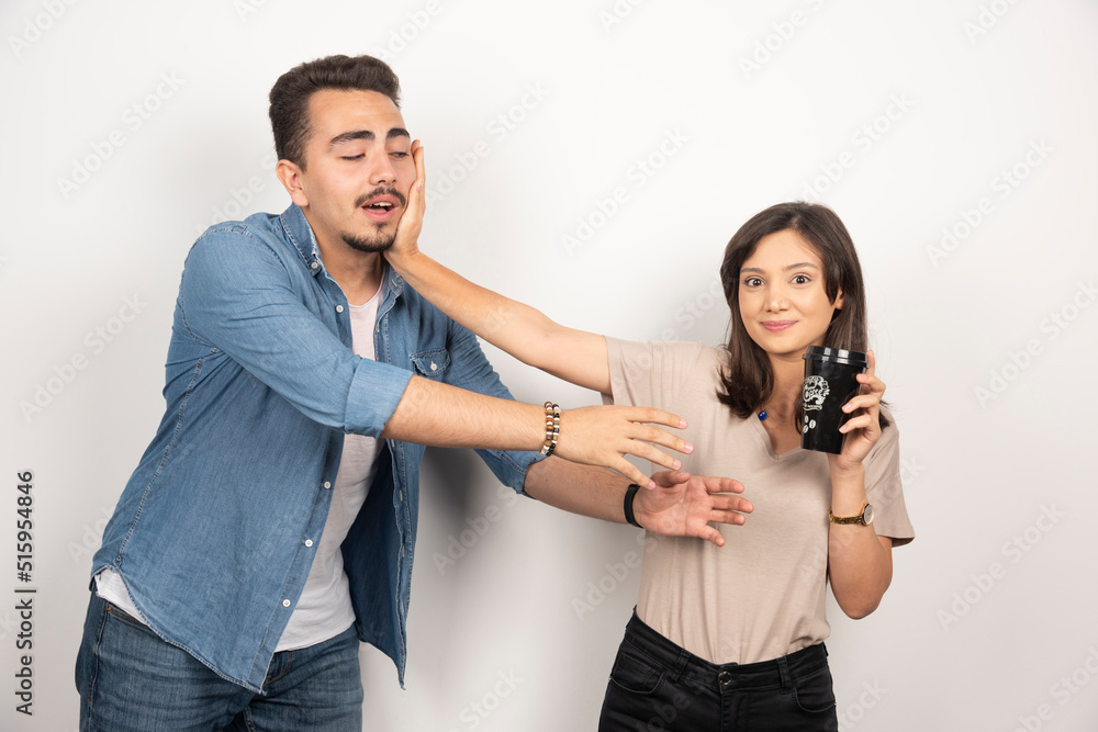 Young woman with black cup repelling a man
