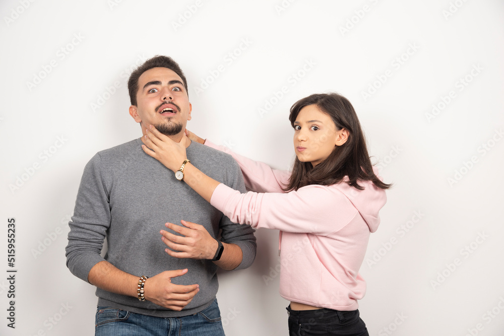 Angry woman playfully choking his boyfriend Angry woman playfully choking his boyfriend