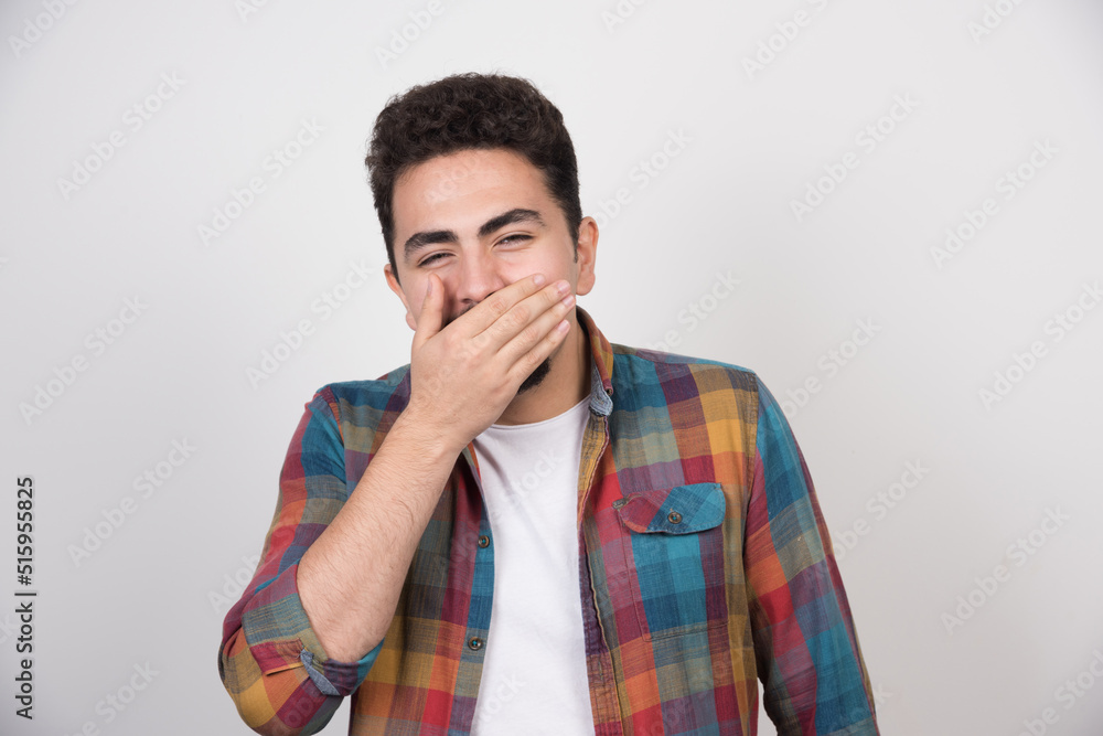 Smiling happy man holding his hand to his mouth Smiling happy man holding his hand to his mouth