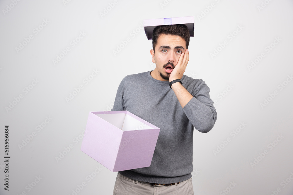 Shocking man holding in hands a purple box Shocking man holding in hands a purple box