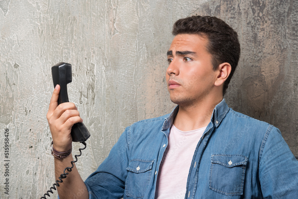 Naklejka premium Photo of wondering man talking on phone and sitting on chair