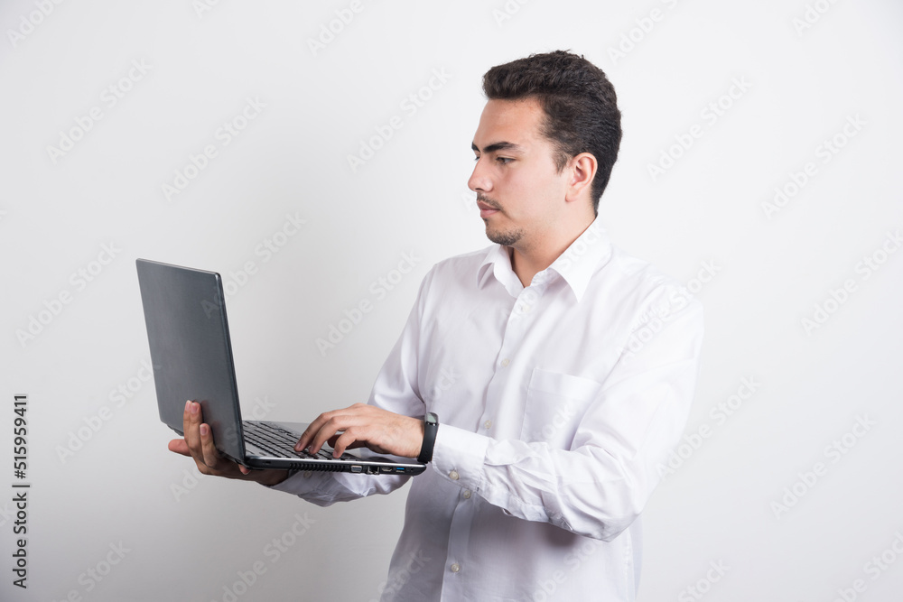 Businessman looking laptop with serious expression on white background Businessman looking laptop with serious expression on white background