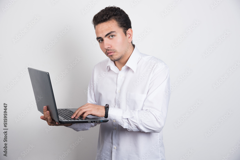 Solemn businessman using laptop on white background Solemn businessman using laptop on white background