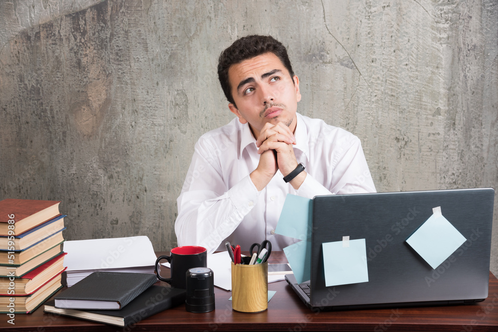 Tired employee looking upside at the office desk Tired employee looking upside at the office desk