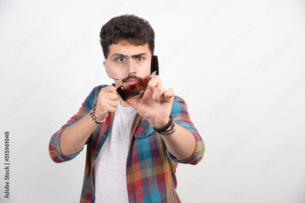 A guy putting a magnifier to his eyes to see bigger A guy putting a magnifier to his eyes to see bigger