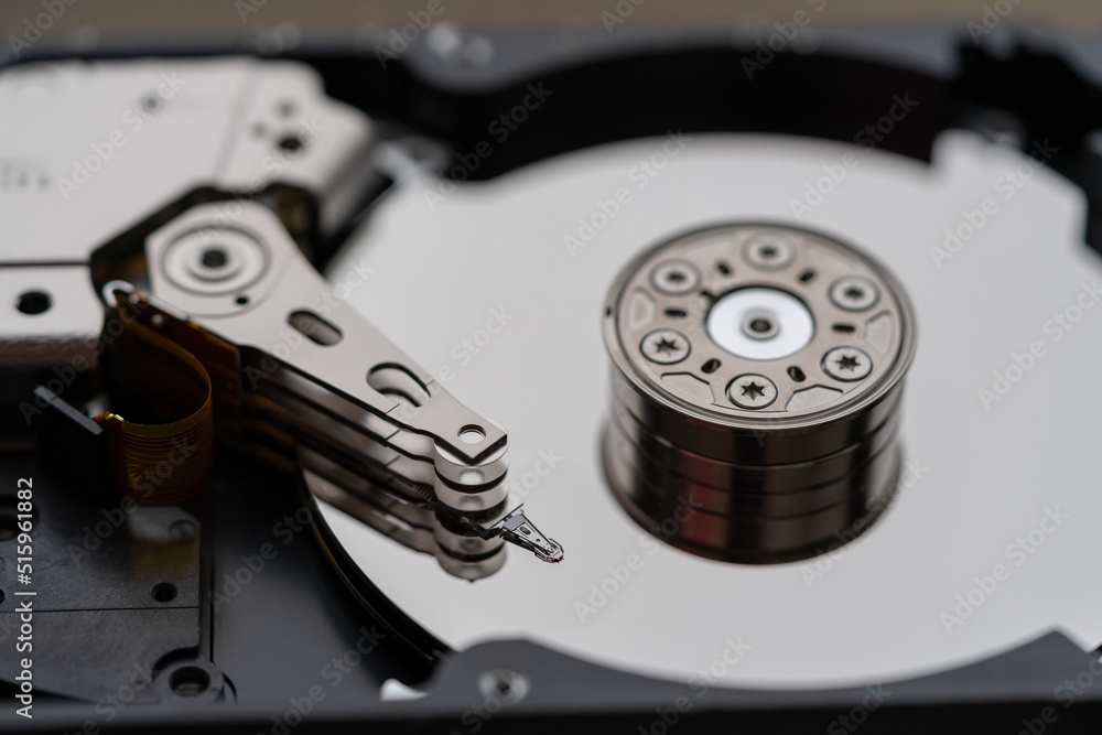 Opened hard disk after disassembly during repair or service, macro shot. Computer HDD inside, selective soft focus. Laptop or PC storage memory Opened hard disk after disassembly during repair or service, macro shot. Computer HDD inside, selective soft focus. Laptop or PC storage memory
