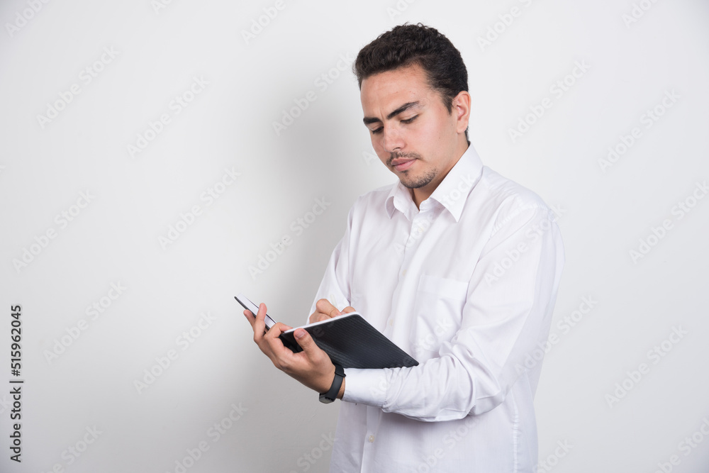 Smiling businessman with notebook posing on white background Smiling businessman with notebook posing on white background