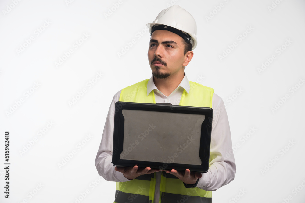 Engineer in uniform holding a laptop and having online meeting Engineer in uniform holding a laptop and having online meeting
