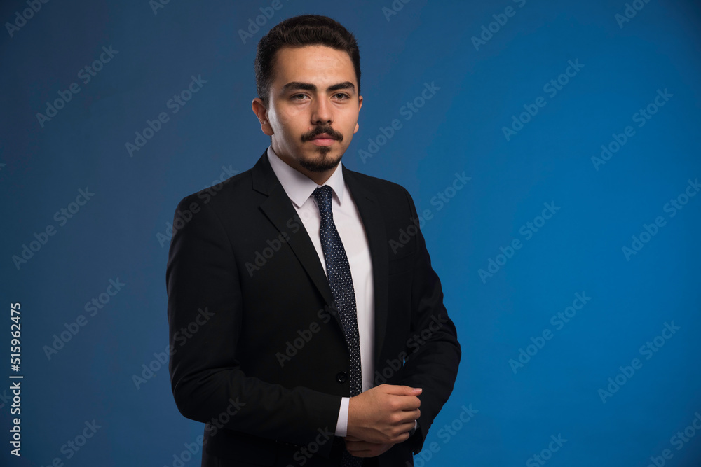 Businessman in black suit with a tie posing Businessman in black suit with a tie posing