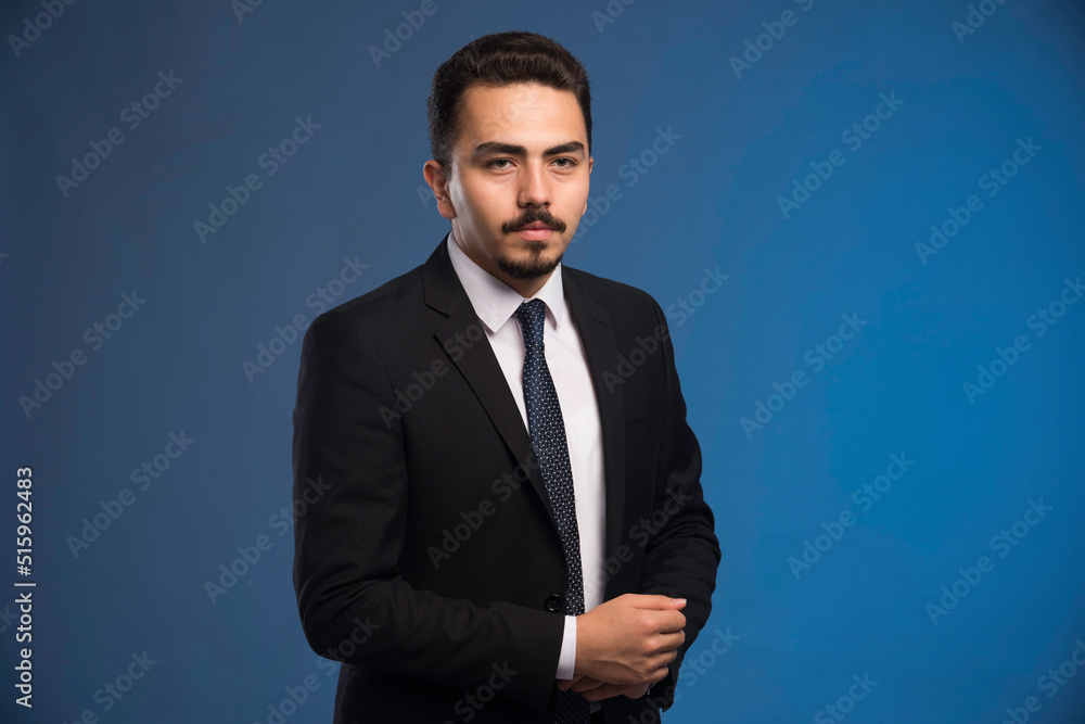 Businessman in black suit with a tie posing Businessman in black suit with a tie posing