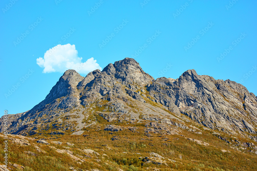 Landscape view of mountains, blue sky with clouds and copy space in Norway. Hiking, discovering scenic countryside and rough terrain. Sun shining on vast background of nature expanse and hiking trail