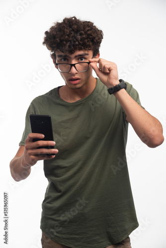 Young boy with curly hairs checking messages and gets surprized © azerbaijan-stockers