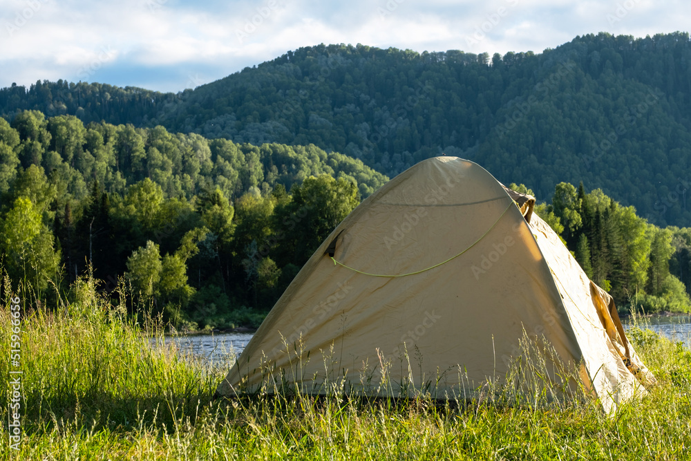 Tourist tent on river bank. Camping tent near mountain river. Local tourism, weekend at nature. Tourist tent on river bank. Camping tent near mountain river. Local tourism, weekend at nature.