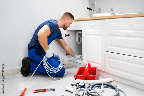 Plumber Cleaning Clogged Sink Pipe