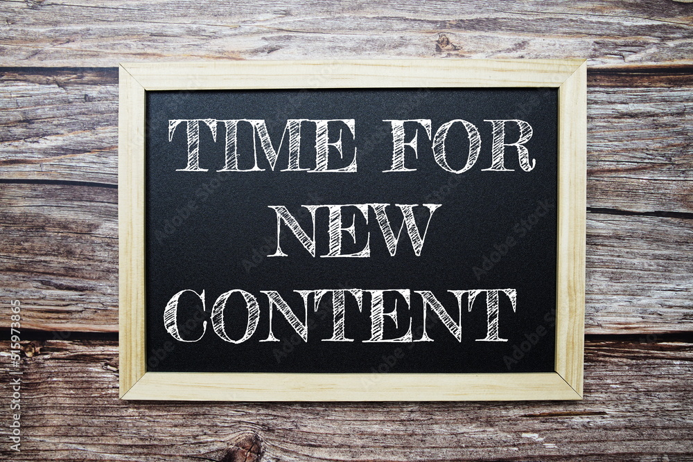 Tim for New Content word with alarm clock on wooden background Tim for New Content word with alarm clock on wooden background