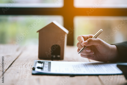 Close of of business's hand signing on agreement paperwork for selling and loan financial house properties.