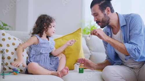 cute caucasian girl daughter laying relax playing tikkle game with her love father on sofa in living room at home,sweet family sunnday weekend morning game dad is play fun with laugh smile of her girl photo