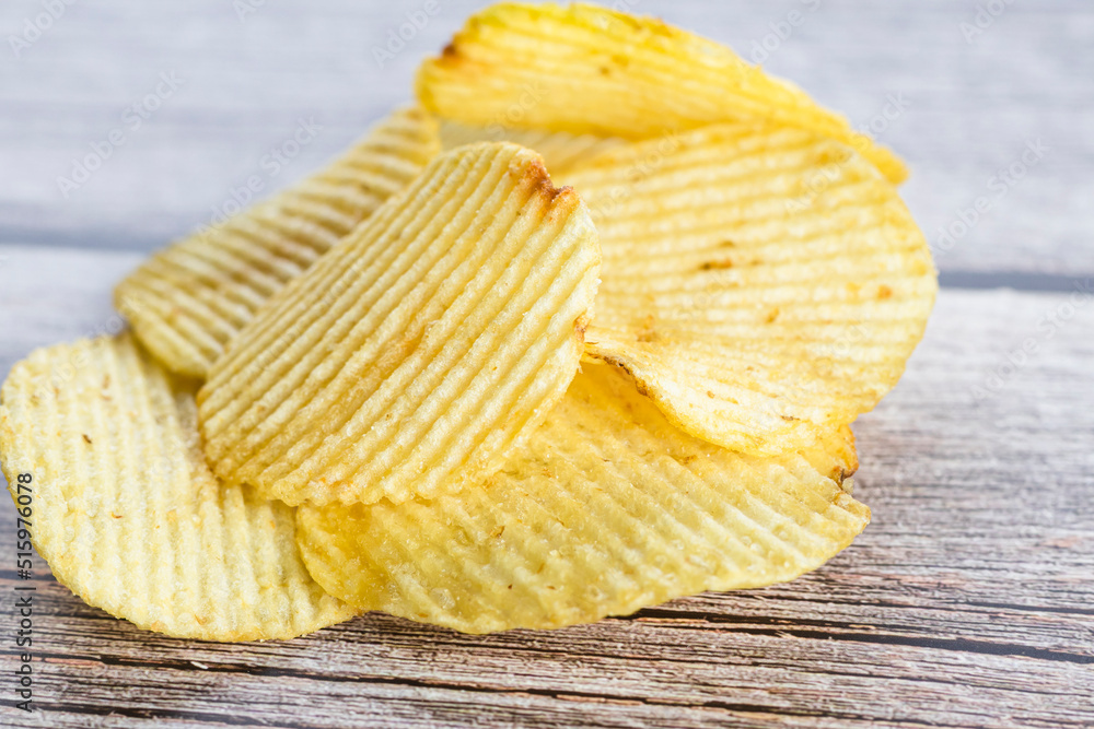 Crispy potato chips on the wood table background. Home made potato chips served with mustard, rosemary, fleur de sel salt on wood background. Copy space. Crispy potato chips on the wood table background. Home made potato chips served with mustard, rosemary, fleur de sel salt on wood background. Copy space.