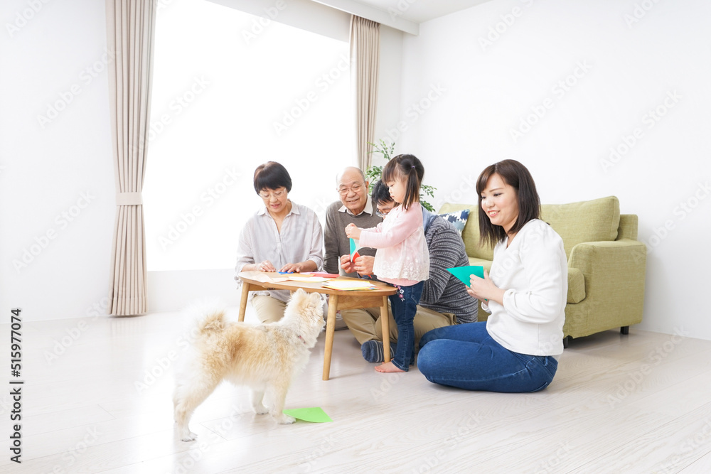 Child and her family playing with paper folding Child and her family playing with paper folding