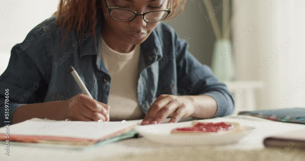 African American student doing homework near toast African American student doing homework near toast