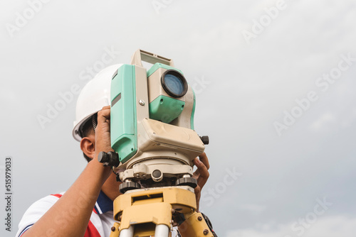 A land surveyor operating a Total Station or RTS. Surveying equipment at the field. photo