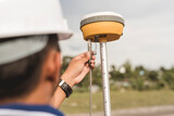A surveyor sets up a Global Navigation Satellite System or GNSS Receiver. Real-time kinematic or RTK geodetic surveying equipment used in the field.