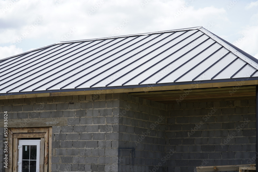 A new house, the roof of which is made of metal. Cottage in the countryside. roof made of modern materials.