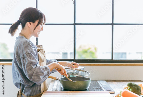 Fotografía キッチンでフライパンを使う女性